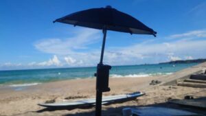 スマホ用遮光傘と青い海とスキムボード